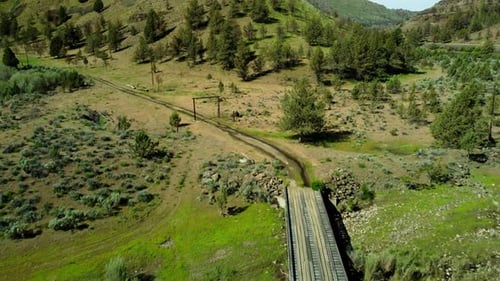 Breathtaking Drone Flight Over a Rugged Mountain Valley and Bridge