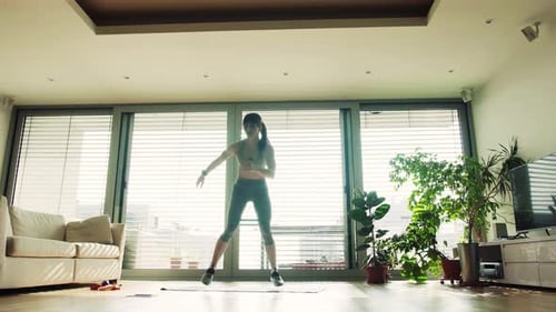 Woman Exercising in Bright Modern Apartment During Daytime