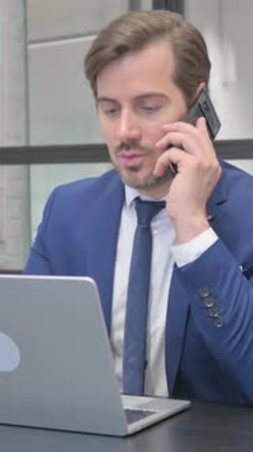 Man in Suit Working and Talking on Phone