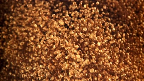 Abstract shot of small golden objects rising