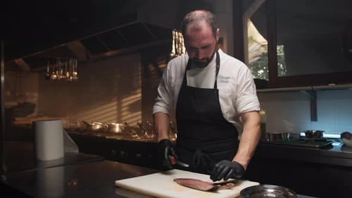 Cook Filleting a Fish on the White Cutting Board of the Restaurant