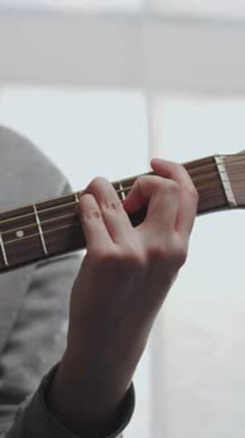 Close Up of Hands Playing Acoustic Guitar Soft Natural Light Relaxed Practice Session Focusing on