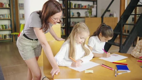 Elementary School Children are Fully Engaged in an Art Class Drawing and Coloring with Pencils and