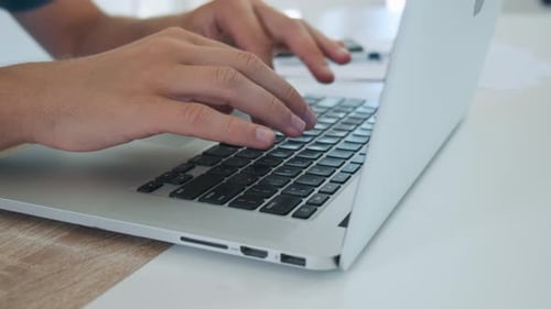Close Up of Man Hands Typing on Laptop Computer Keyboard and Surfing Internet on the Table Online