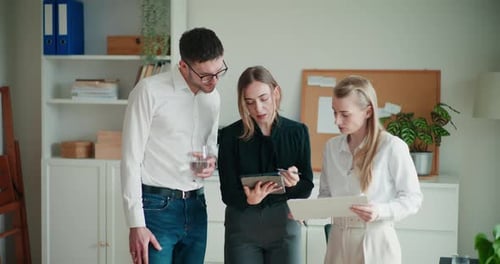 Group Discussing Tablet in Office Setting