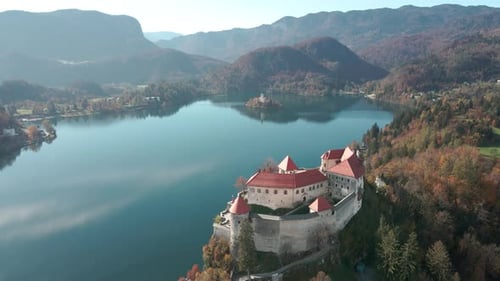Beautiful aerial dolly overlooking clifftop castle lake bled Slovenia sunny day