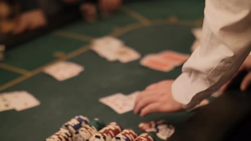 Casino Dealer Distributing Cards at Poker Table