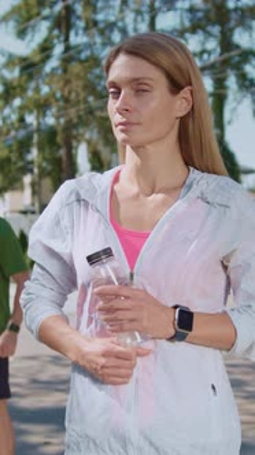 Smiling Fit Woman Holds Water Bottle Outdoors