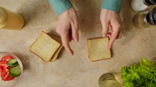 Top-Down View: Preparing Sandwiches with Yellow Sauce