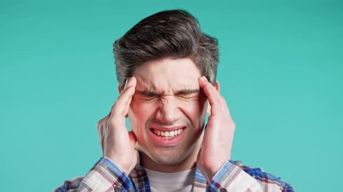 Young Man Having Hypertension Headache Blue Studio Guy Putting Hands on Head