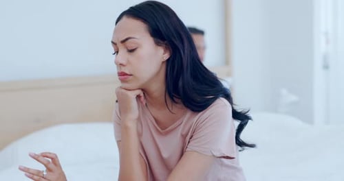 Sad Couple Sitting in Bed After Argument