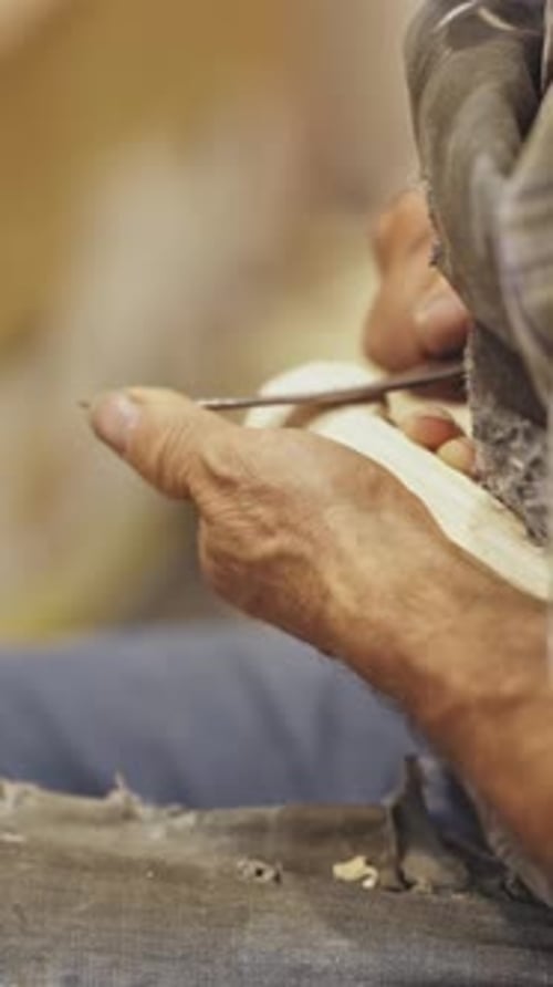 Wood Carver Shaping Intricate Design with Sharp Tool