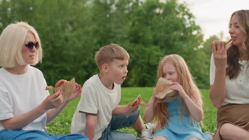Mothers and Kids Enjoying Snacks on Picnic Mat in Park