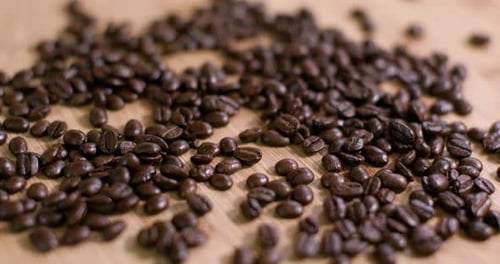 Pile of Dark Roasted Coffee Beans on Wood