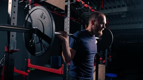 young motivated bodybuilder squatting with heavy barbell in gym exercise active lifestyle body care