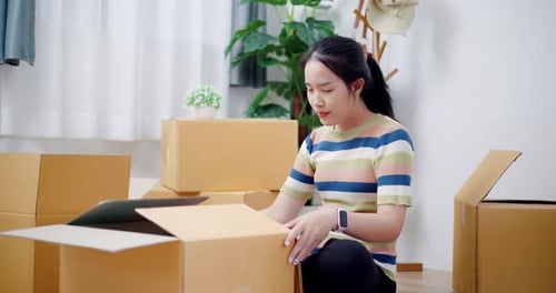 Woman Packing Boxes in Her Home