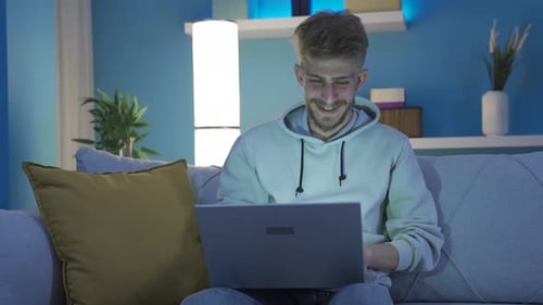 Man Using Laptop on Sofa at Home