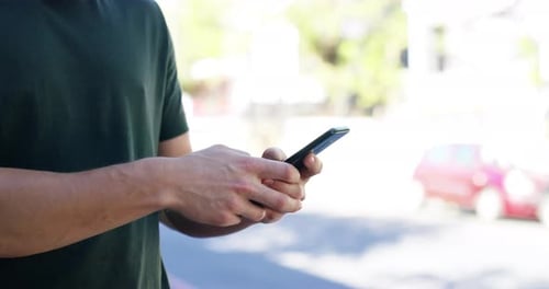 4k video footage of an unrecognizable man sending text messages while out in the city