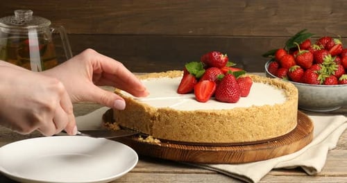 Fresh Strawberry Cheesecake Being Cut and Served