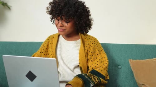 African American Girl Using Laptop at Home Office Looking at Screen Typing Chatting Reading Writing