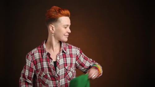 Smiling Young Adult with Rainbow Flag and Piercings