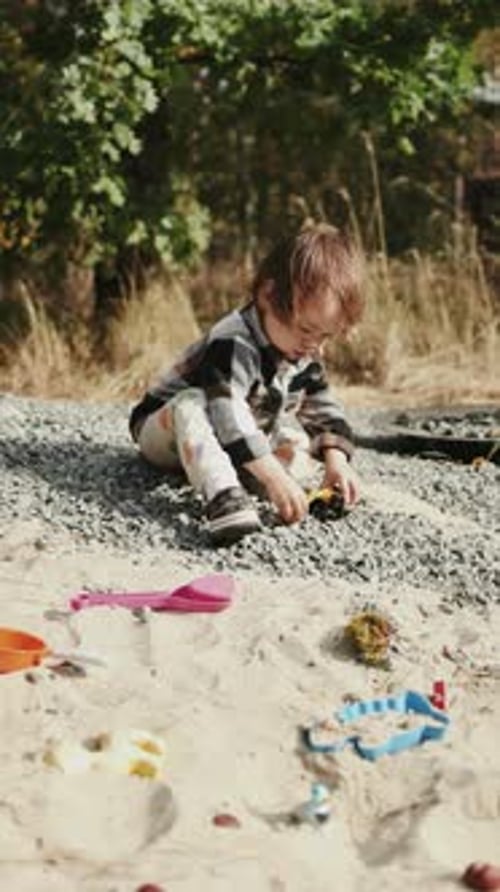 A Child Enthusiastically Playing on the Beach with Colorful Toys in a Natural Setting