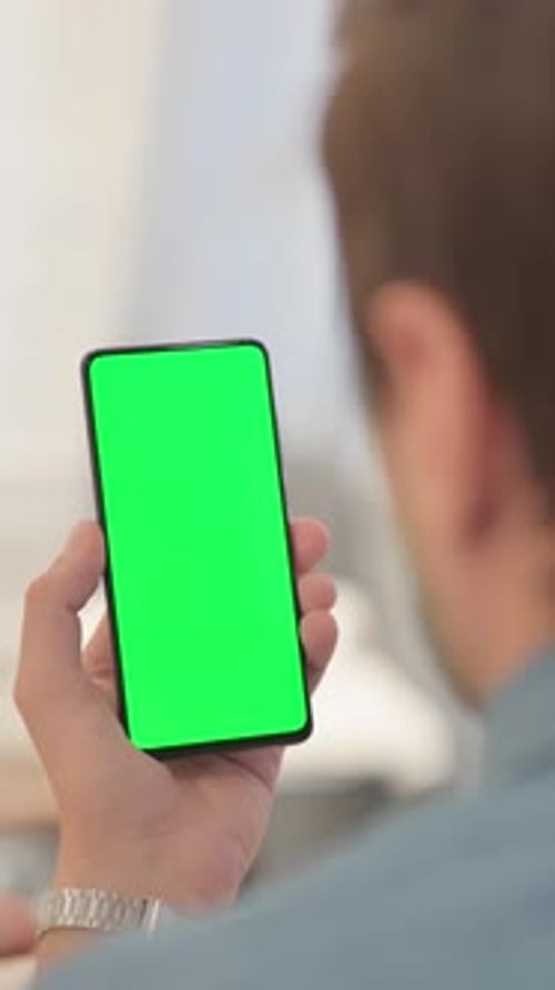 Mann benutzt Telefon mit grünem Bildschirm, vertikales Video