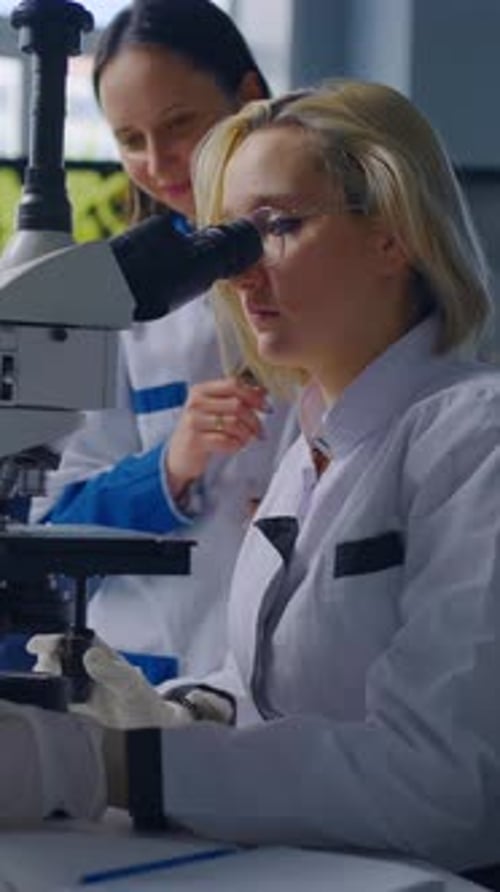 Fokussierte Wissenschaftlerinnen arbeiten mit Mikroskopen und Laborglaswaren in der modernen Forschung