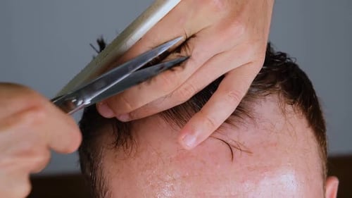 Man Getting Haircut with Scissors and Comb