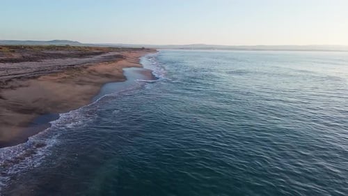 Black Sea and Beach Nearby Against a Sky with Clouds and a Dawn Sun