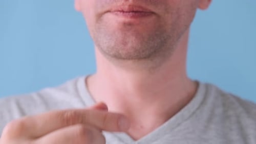 Adult Taking White Pill and Drinking Water