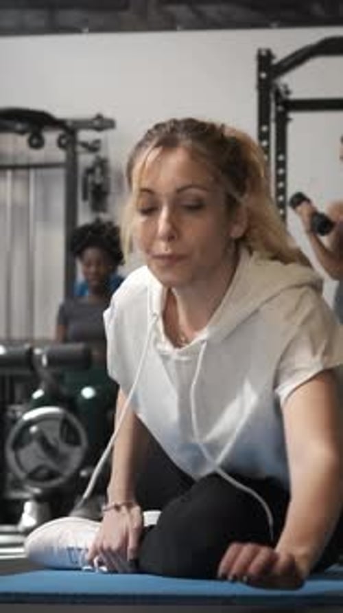 Fitness Woman Doing Stretching Exercises After Working Out at the Gym
