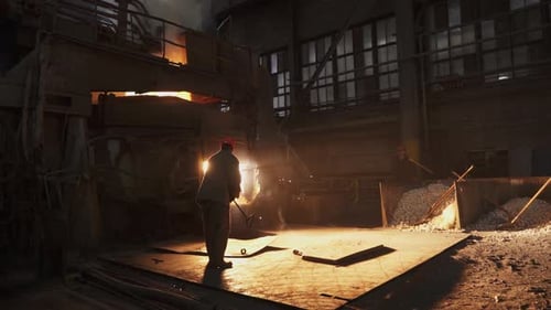 An Industrial Worker Skillfully Engaged in the Art of Casting Metal in a Vibrant Factory Environment