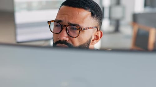 Man Looking at Computer Screen Wearing Glasses