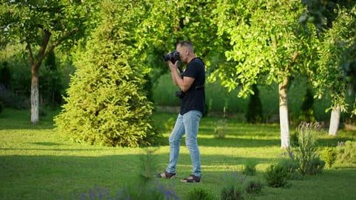 Man Taking Photos in Green Garden Setting