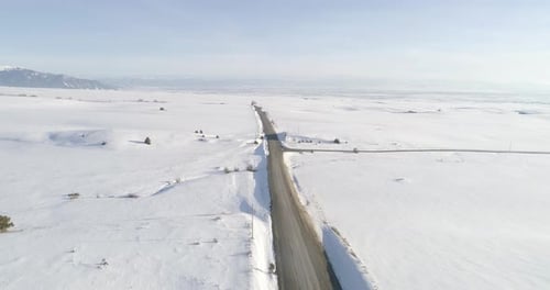 Landstraße mitten im Nirgendwo, die vor Schneefall gepflastert ist
