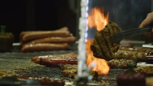 Grilling Meat and Hotdogs with Tongs Close Up