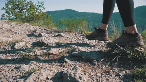 View on Feet of Traveler Woman Hiking Walking on the Top of Cliff in Mountain Walking on Rocks