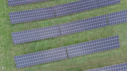 Aerial View of Solar Panels on Green Field