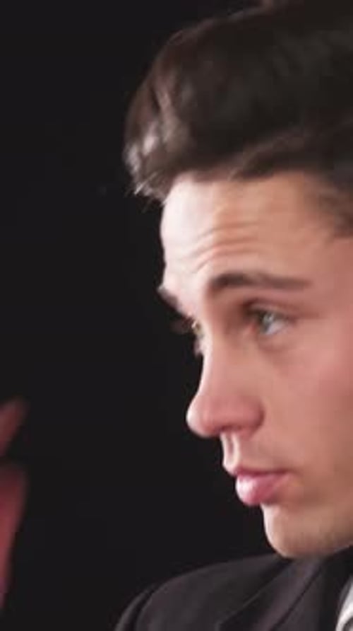 Attractive man in a suit adjusts his hair