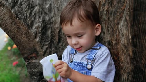 Cute smiling baby boy looks at the book with interest.