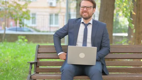Businessman Working on Laptop, Sitting on Park Bench