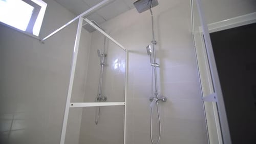 Two Silver Shower Heads in a White Bathroom