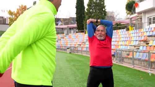 Senior Men Stretching at an Outdoor Track