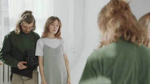 Female Model and Photographer Taking Pictures in front of Mirror in Studio