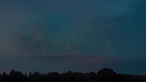 Timelapse of a heavy lightning storm flashing and rolling over evening darkness