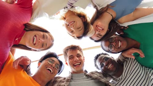 Low Angle View of a Group of Multiracial Friends Standing on a Circle Smiling and Embracing Together