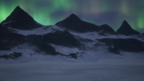 Rocky Mountain Landscape at Night with Stars and Northern Lights in Sky
