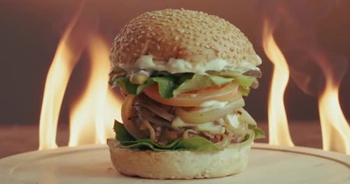 Burger, flame and rotation with fast food in restaurant for hospitality or take away order
