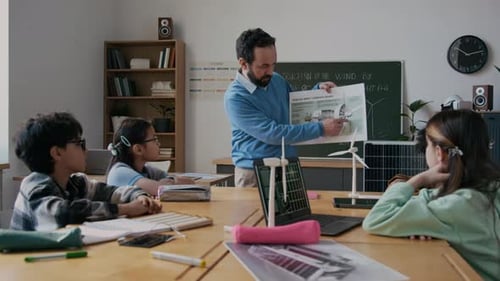 Male Ecology Teacher Explaining Wind Turbine Concept to Young Pupils